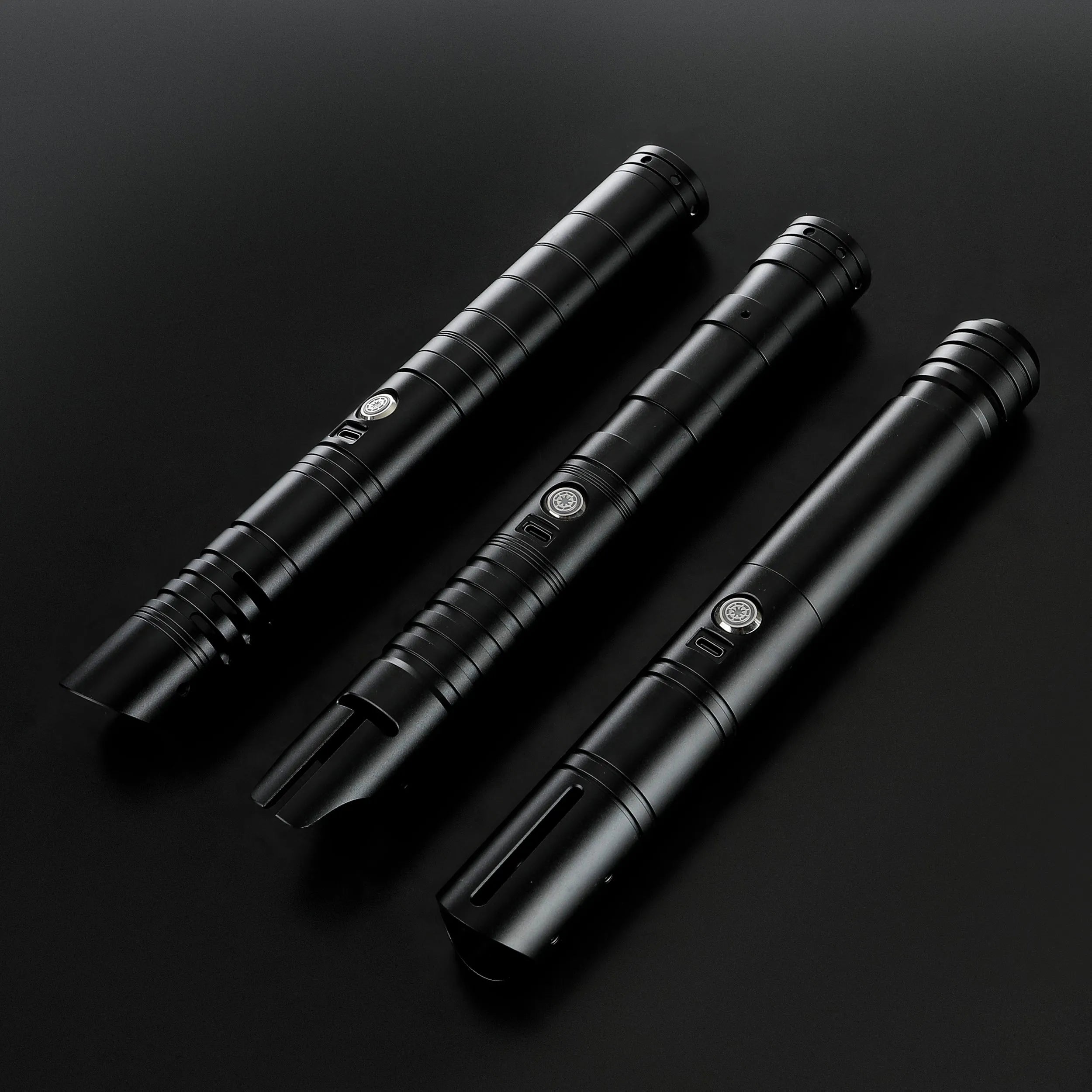 Three black T6 aluminum alloy dueling sabers: Defender, Hunter, and Enforcer 2, on a dark surface.