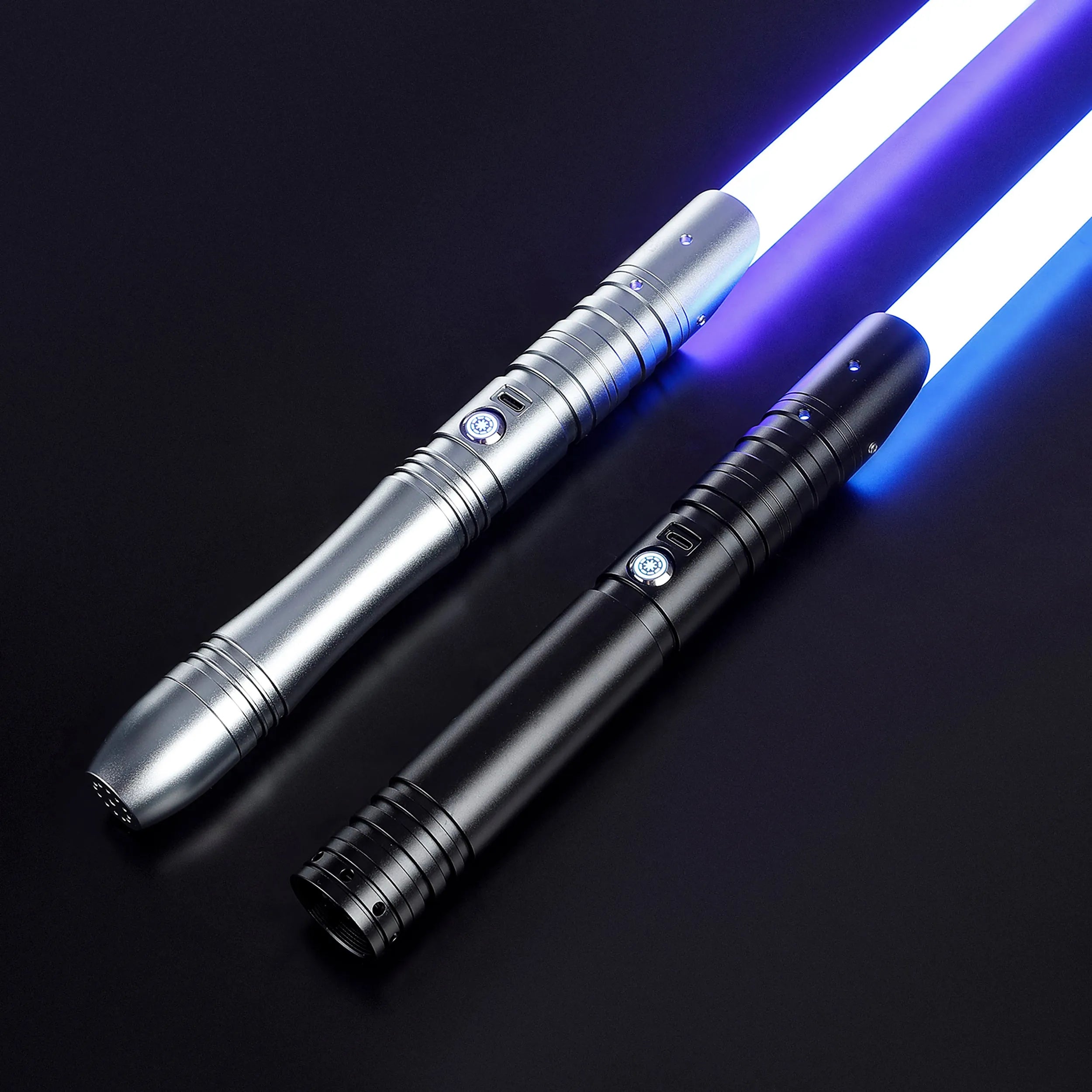 Two aluminum sabers with glowing blue baselit blades: one silver, one black, on a dark background.