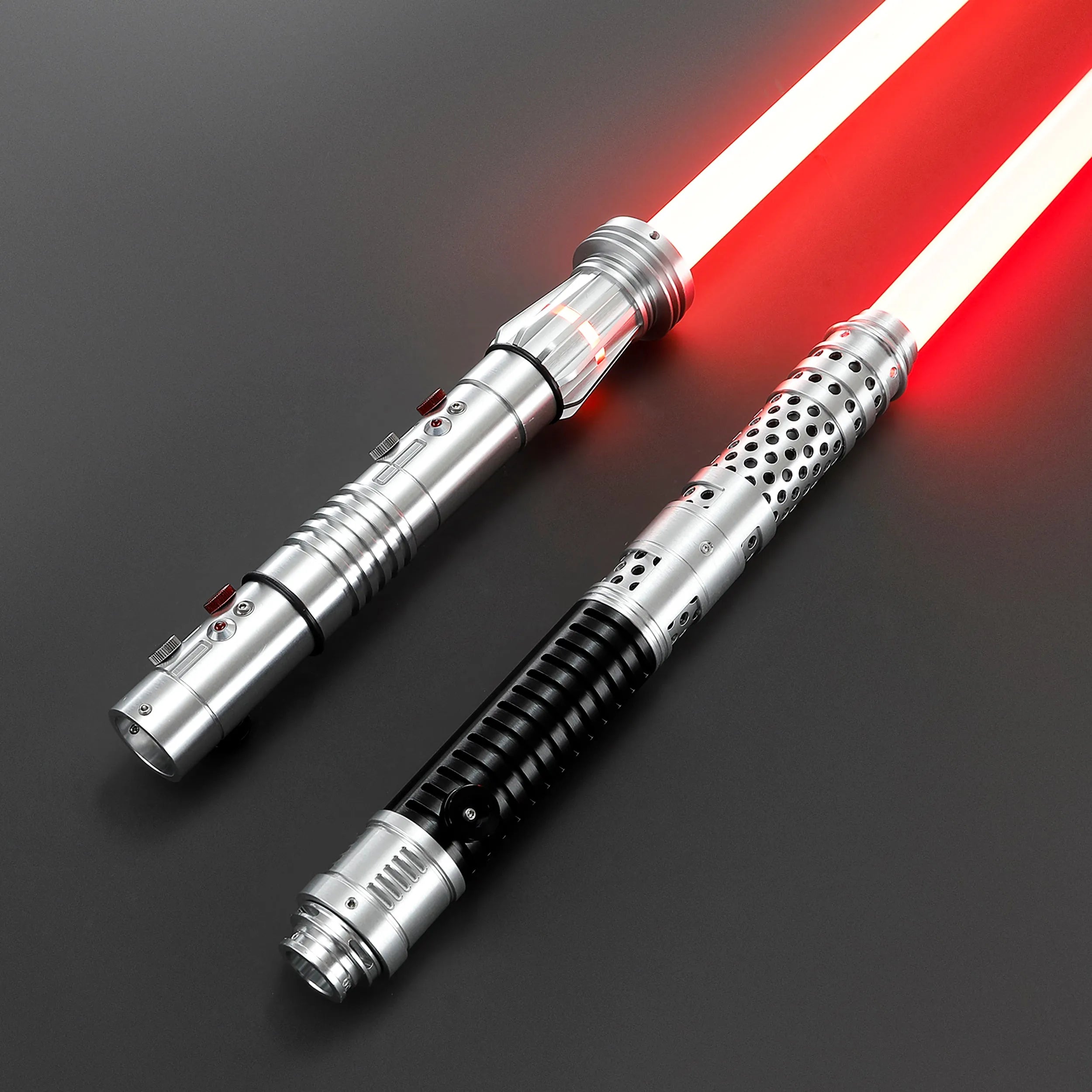 Two brushed silver metal Shadow Lord saber hilts with glowing red blades, one with a black grip.