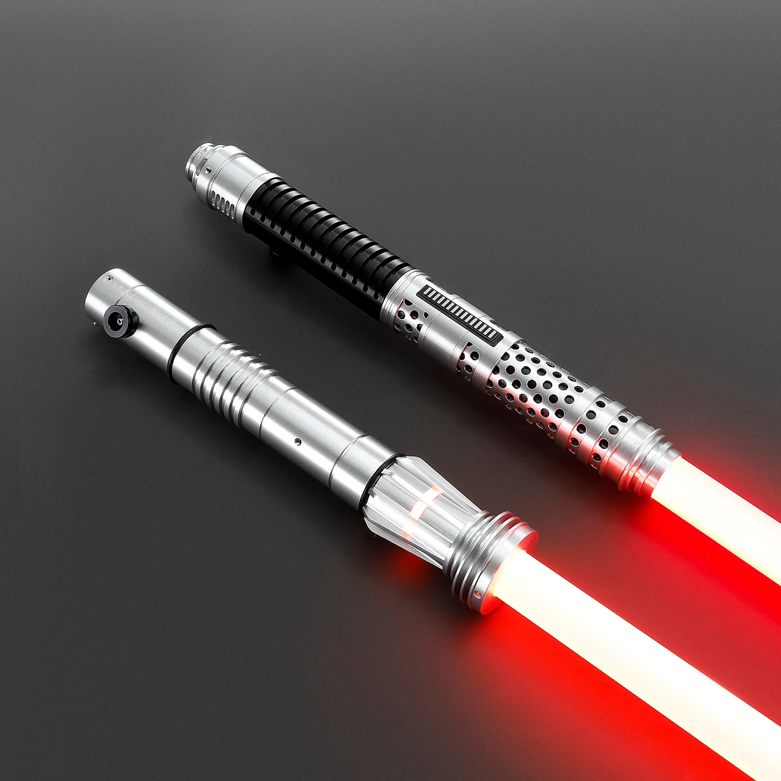 Two brushed silver metal Shadow Lord saber hilts with glowing red polycarbonate blades, one with black grip.