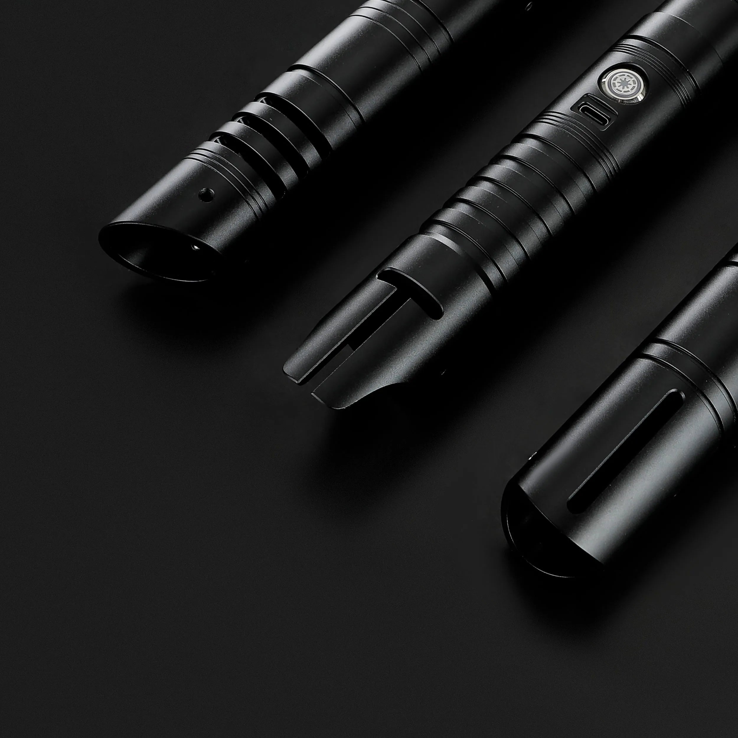Three black T6 aluminum alloy dueling sabers: Defender, Hunter, and Enforcer 2, on a dark background.