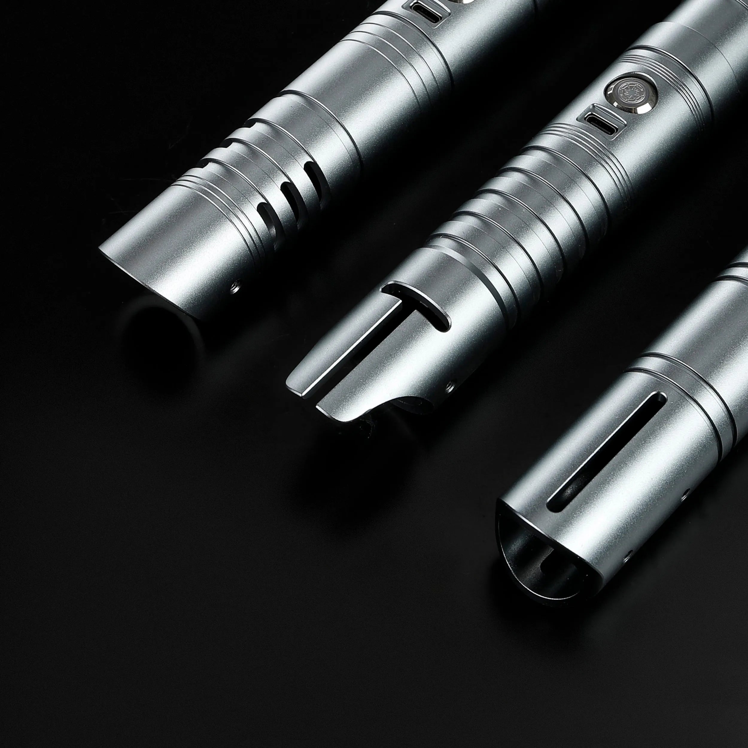 Three silver T6 aluminum alloy dueling saber hilts: Defender, Hunter, and Enforcer 2, on a black background.