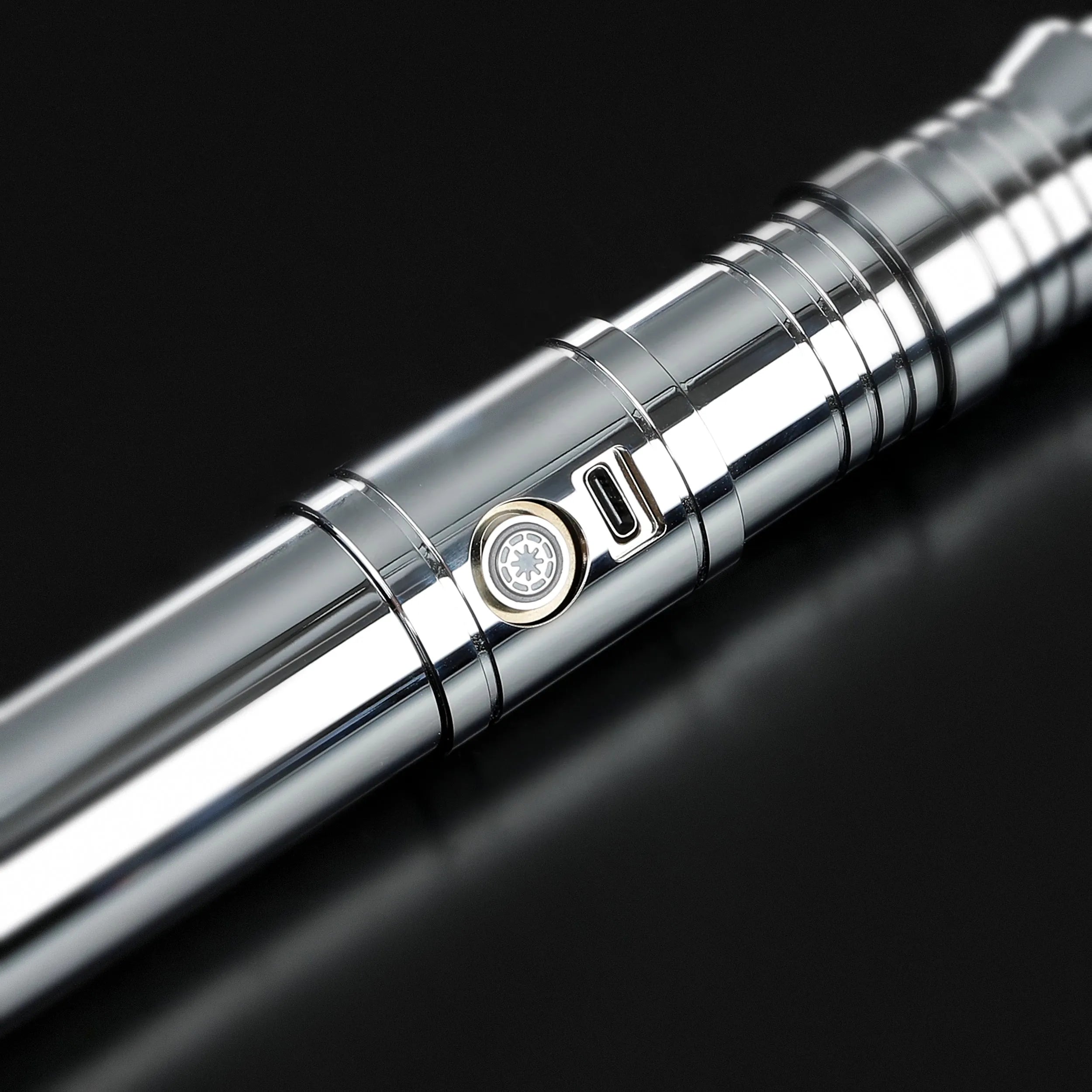 Chrome Darth Revan lightsaber hilt with a gold-ringed activation button and USB-C port, ideal for heavy dueling.