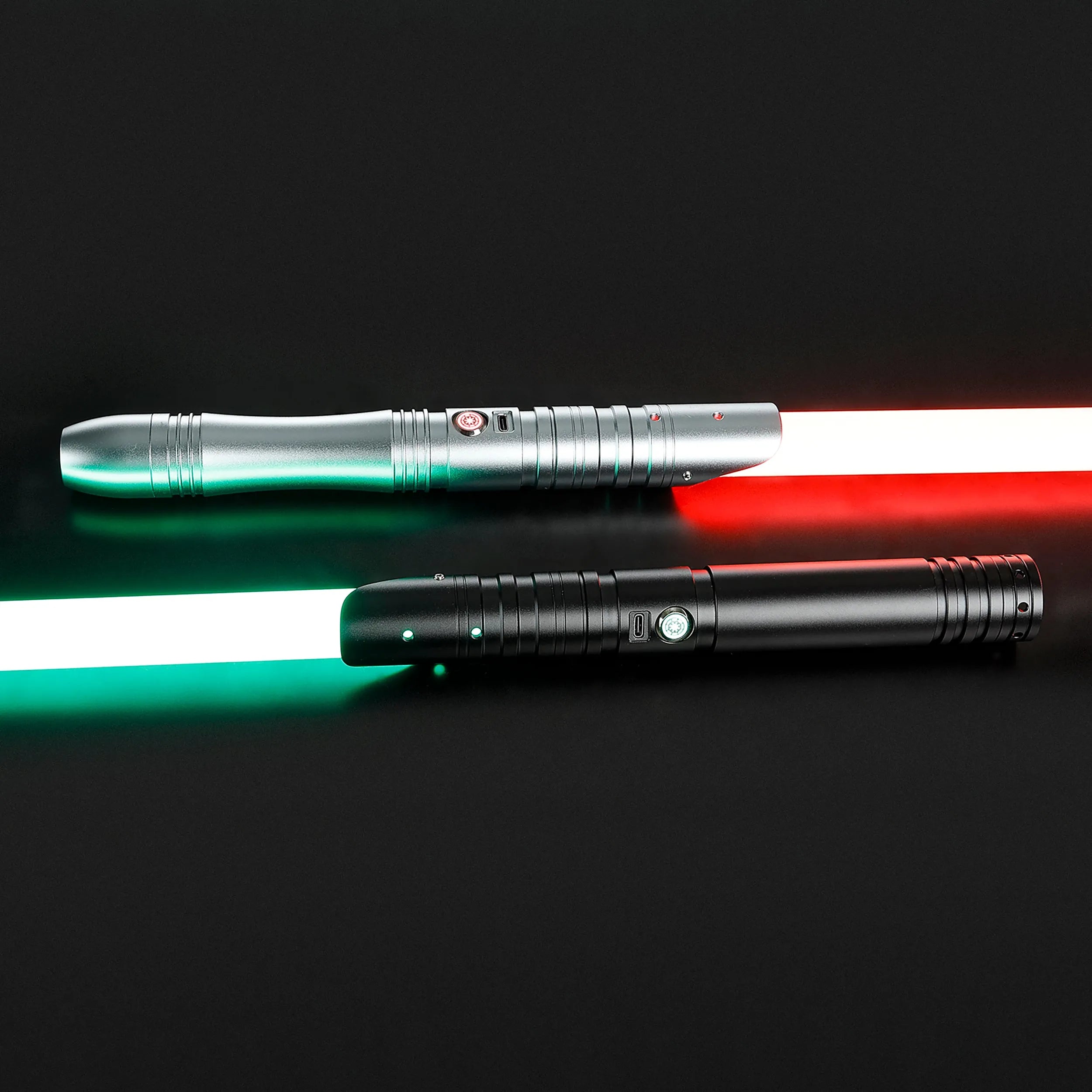 Two aluminum alloy sabers: one silver with a red blade, one black with a green blade, on a dark background.