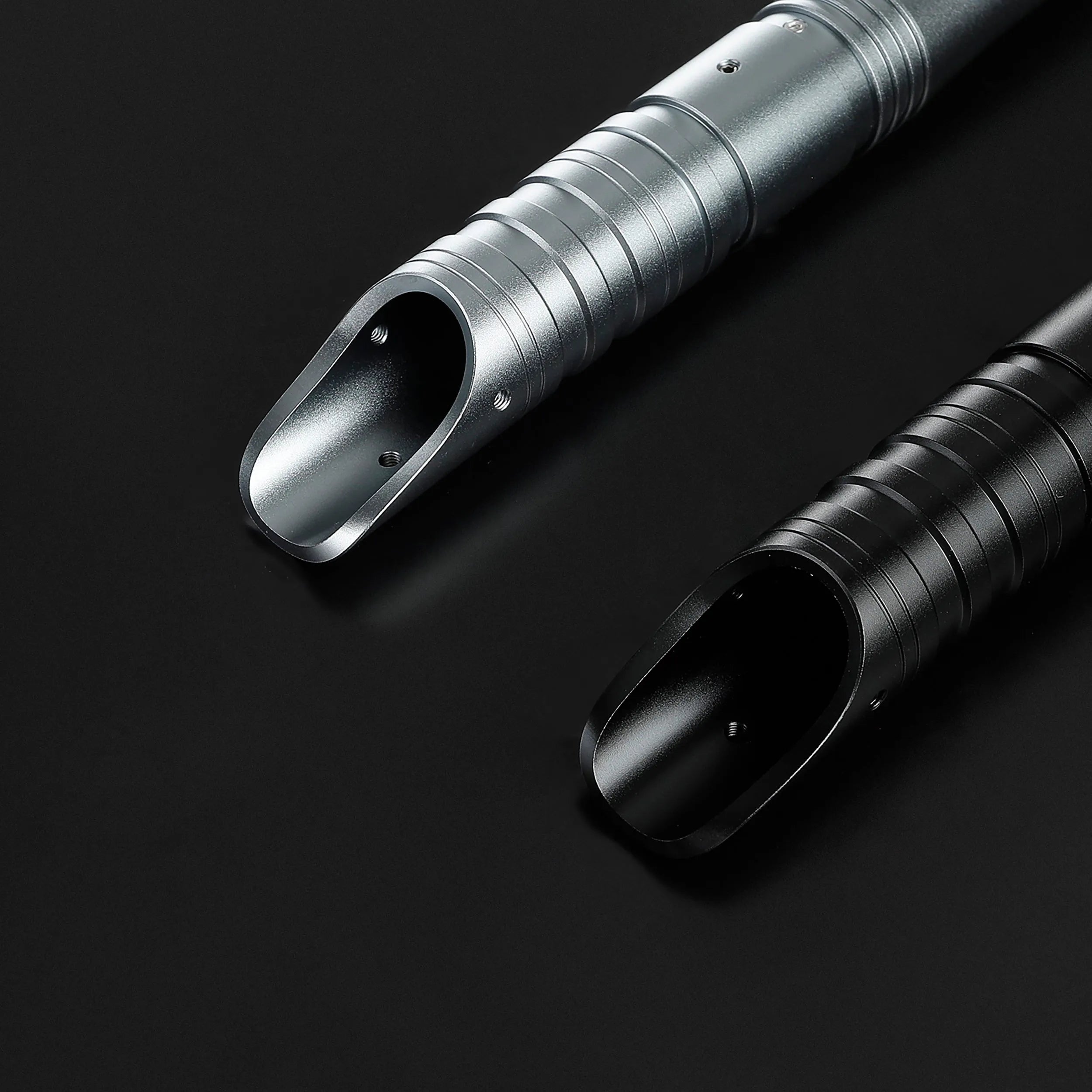 Two durable T6 aluminum alloy saber hilts, one silver and one black, with ribbed grips.