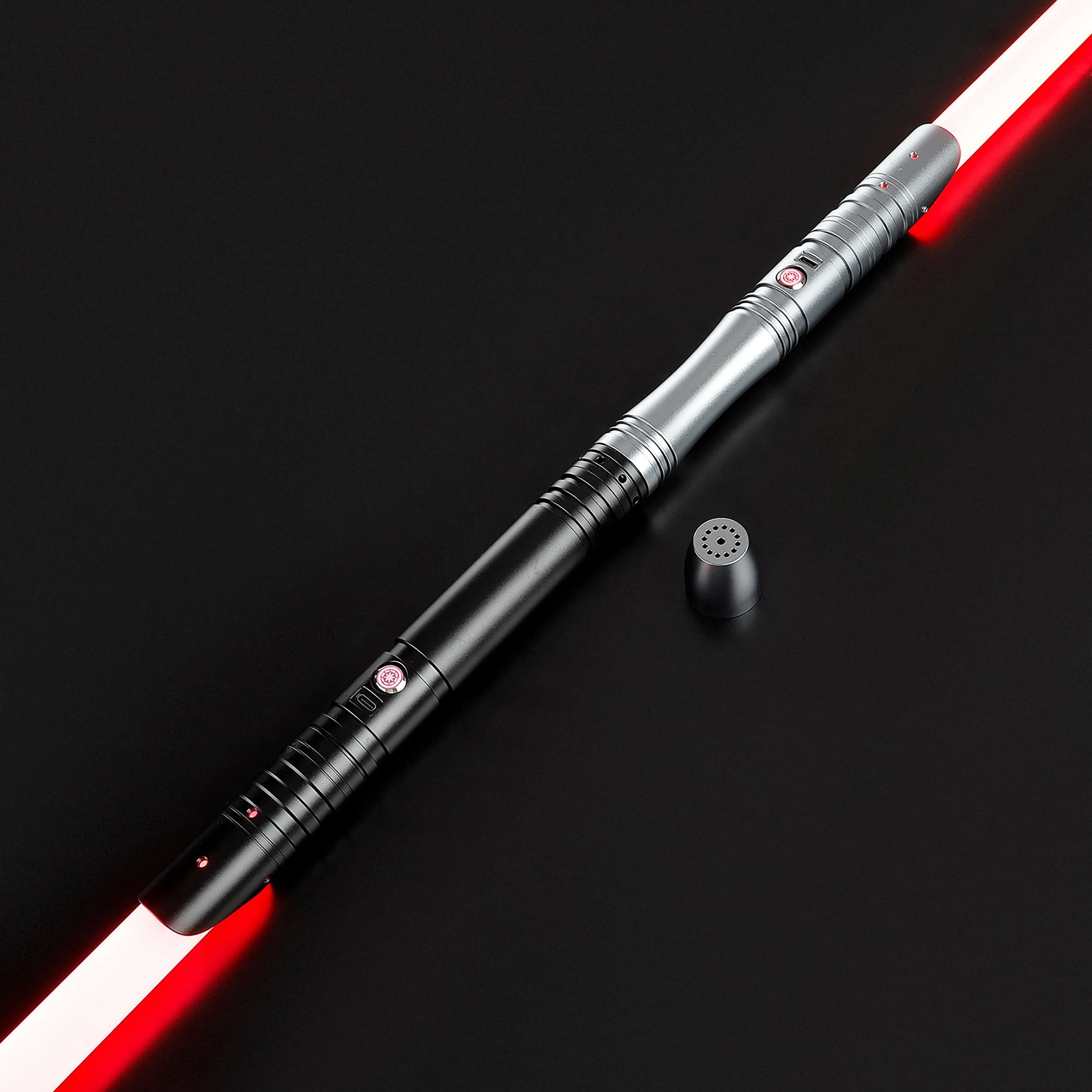 Two-toned aluminum alloy saber with a red baselit blade, black and silver hilt, and speaker cap.