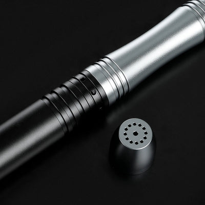 Close-up of a sleek black and silver aluminum saber hilt with a detached speaker pommel.