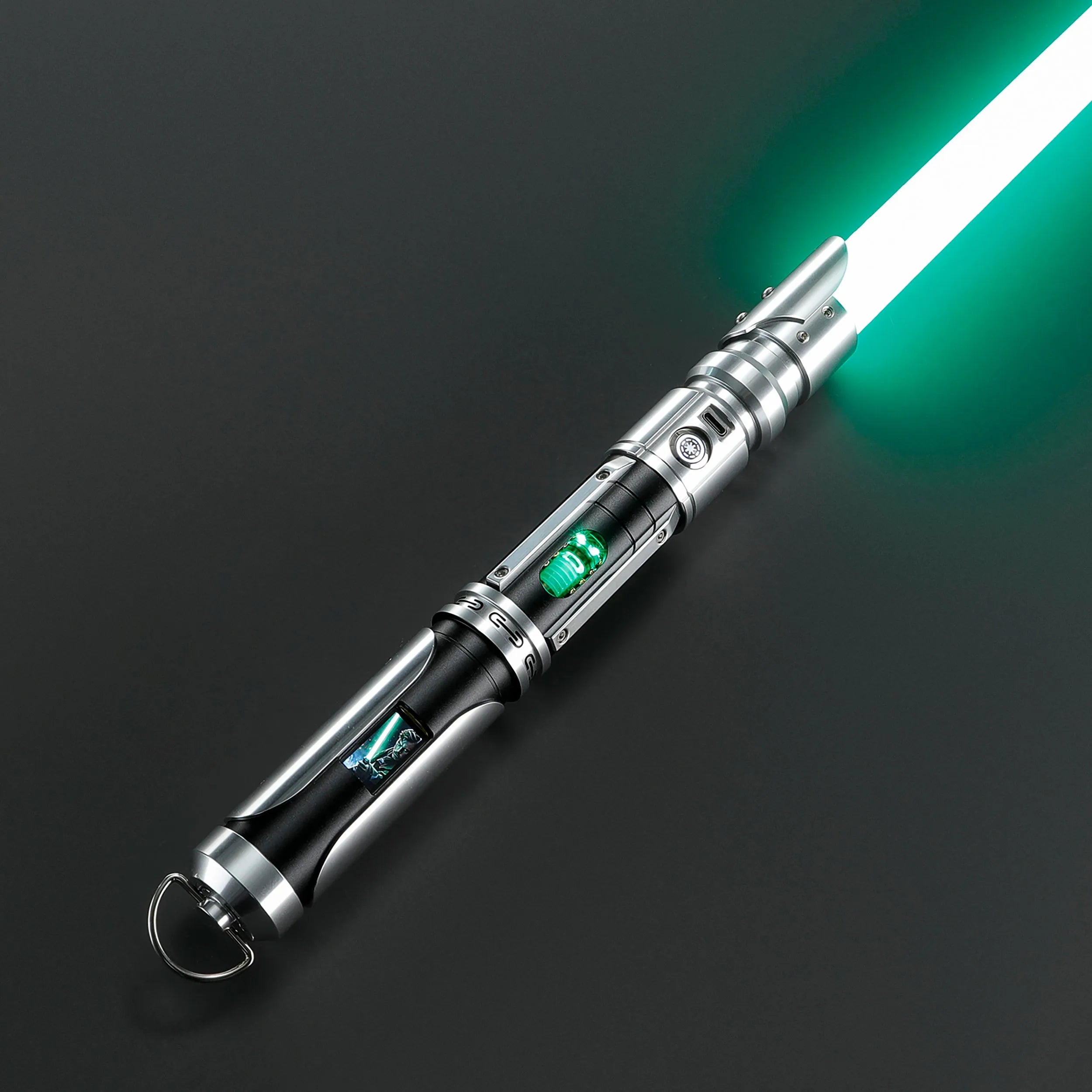 Paragon Xenopixel V3 saber with silver and black aircraft-grade aluminum hilt, exposed glowing kyber crystal, and green blade.