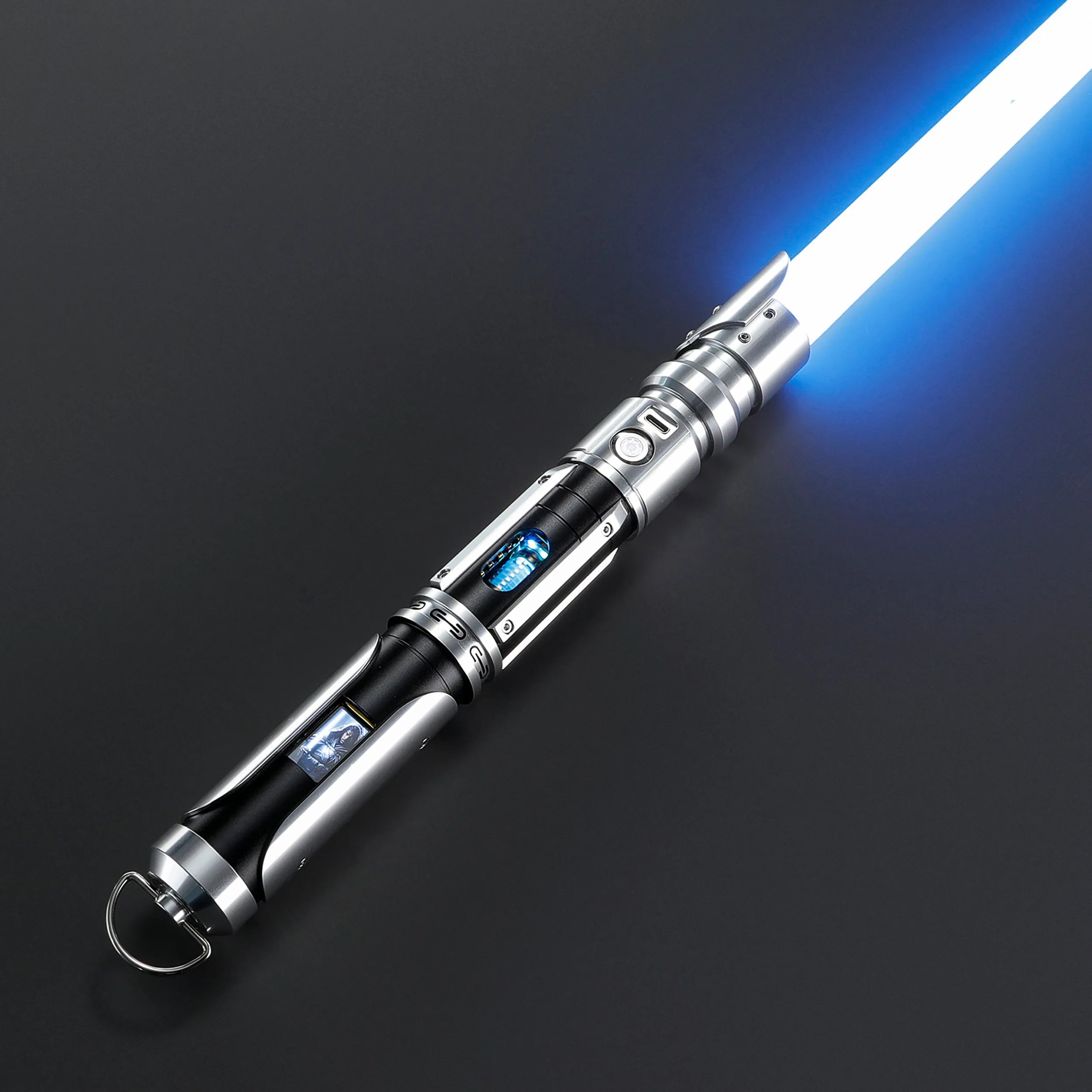 Paragon Xenopixel V3 saber with glowing blue blade, silver and black aircraft-grade aluminum hilt, exposed kyber crystal, and OLED display.