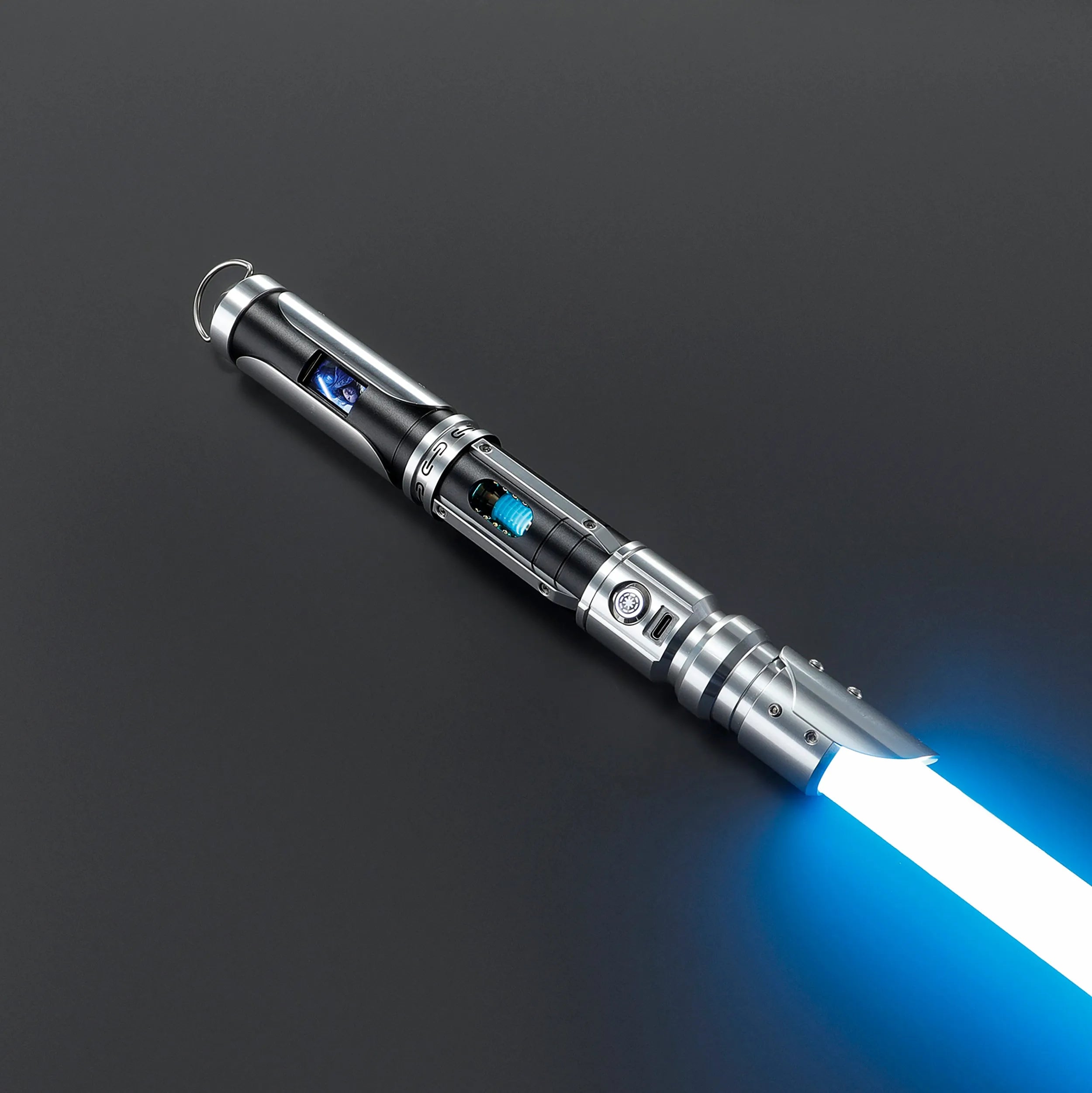 Paragon Xenopixel V3 saber with polished silver and black aircraft-grade aluminum, exposed blue kyber crystal, OLED, and glowing blue blade.