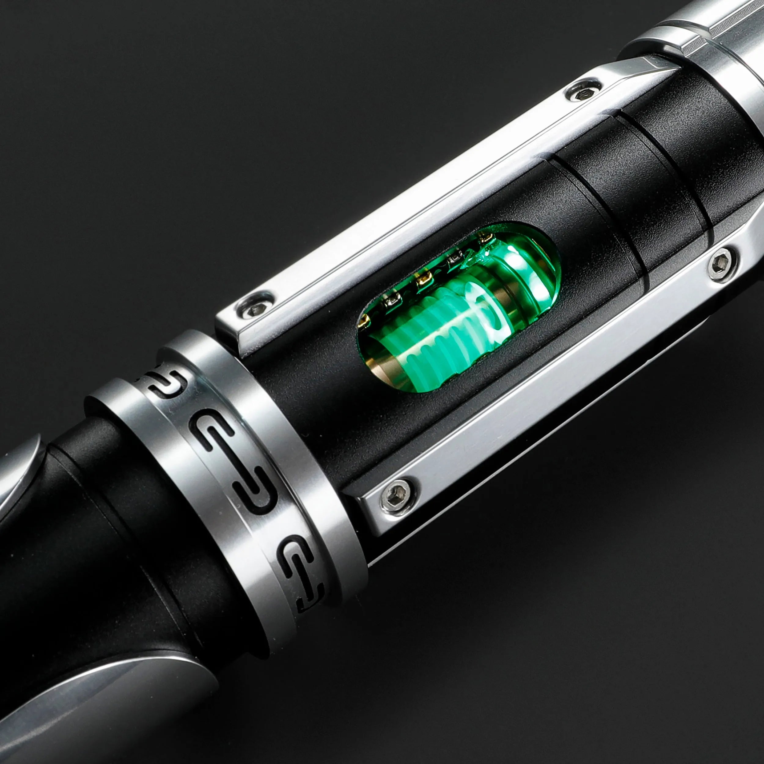 Paragon Xenopixel V3 saber hilt with exposed glowing green kyber crystal, crafted from black and silver aircraft-grade aluminum.
