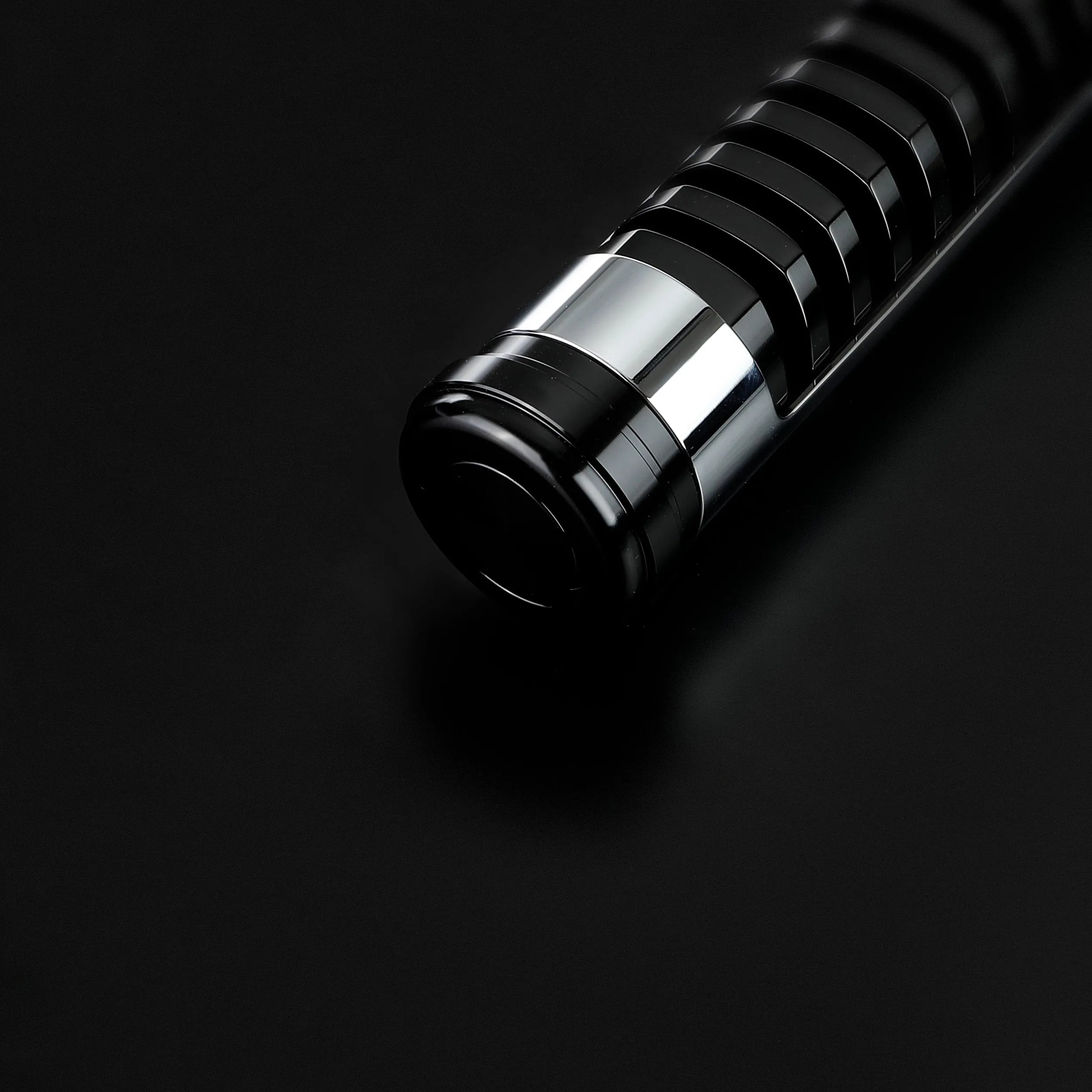 Sleek black and chrome Qui-Gon Jinn lightsaber hilt, T60 aluminum, on a dark surface.
