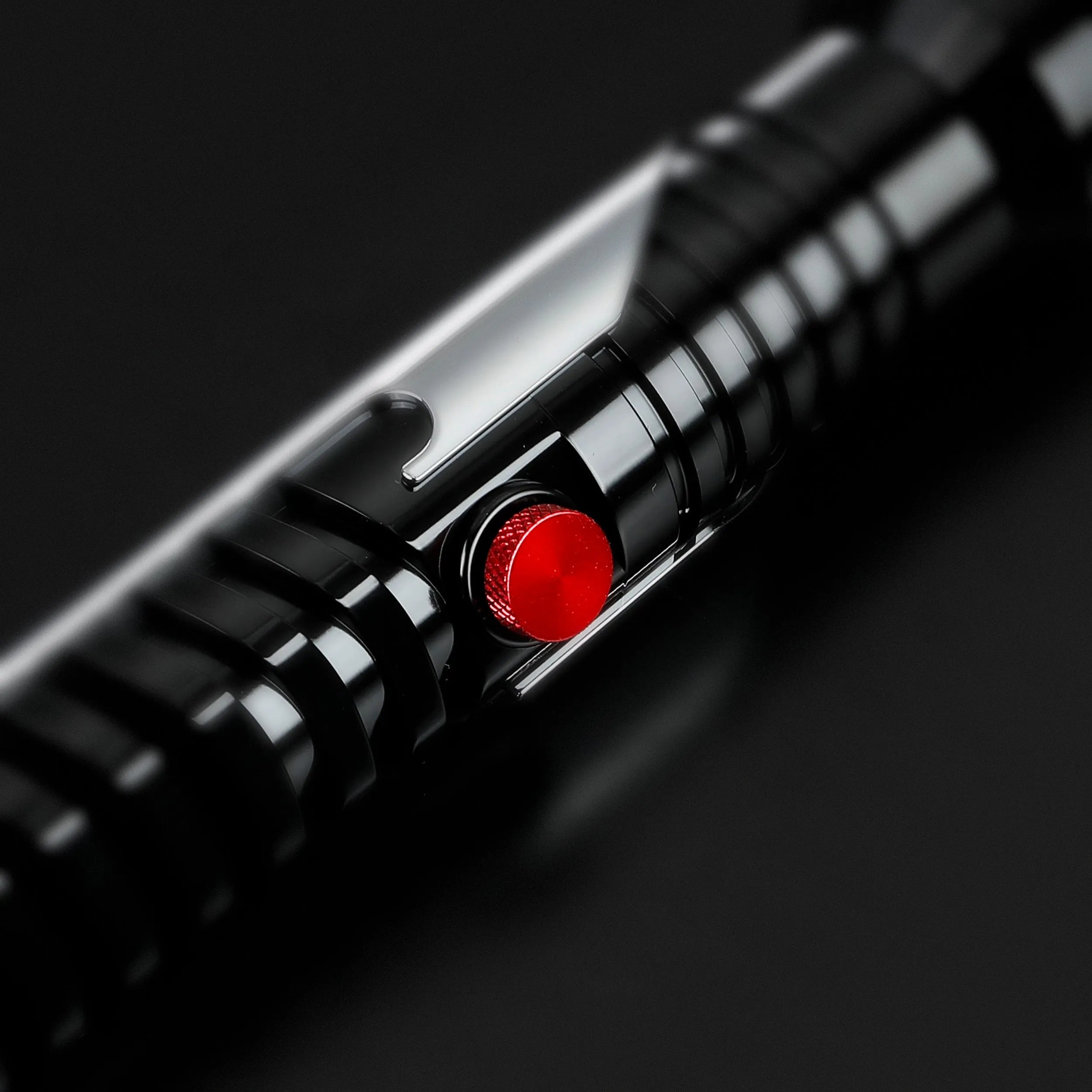 Qui-Gon Jinn lightsaber hilt, black T60 aluminum with ribbed grip, silver accents, and a prominent red activation button.