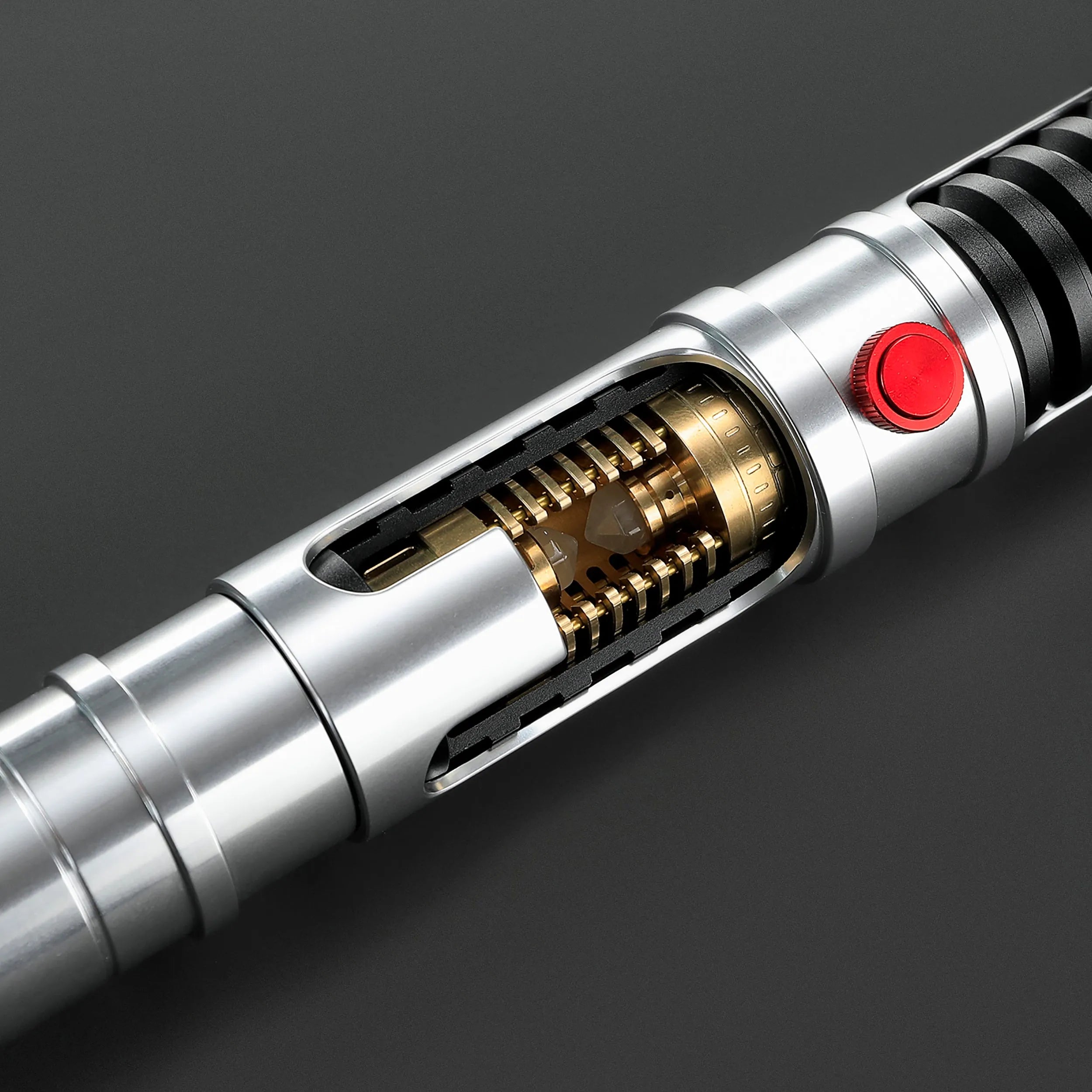 Quinlan Vos lightsaber hilt: brushed aluminum, visible golden kyber chamber, red activation button, black grip.
