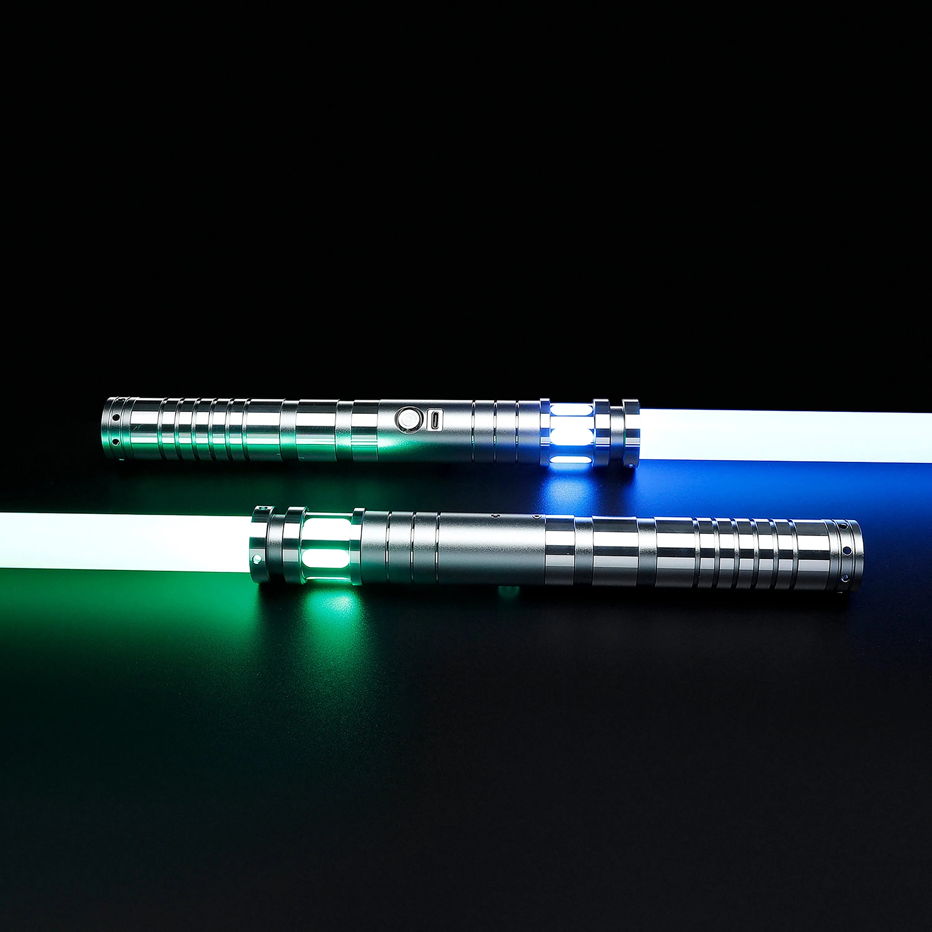 Two silver T6 aluminum Sol lightsabers with glowing blue and green polycarbonate blades on a black background.