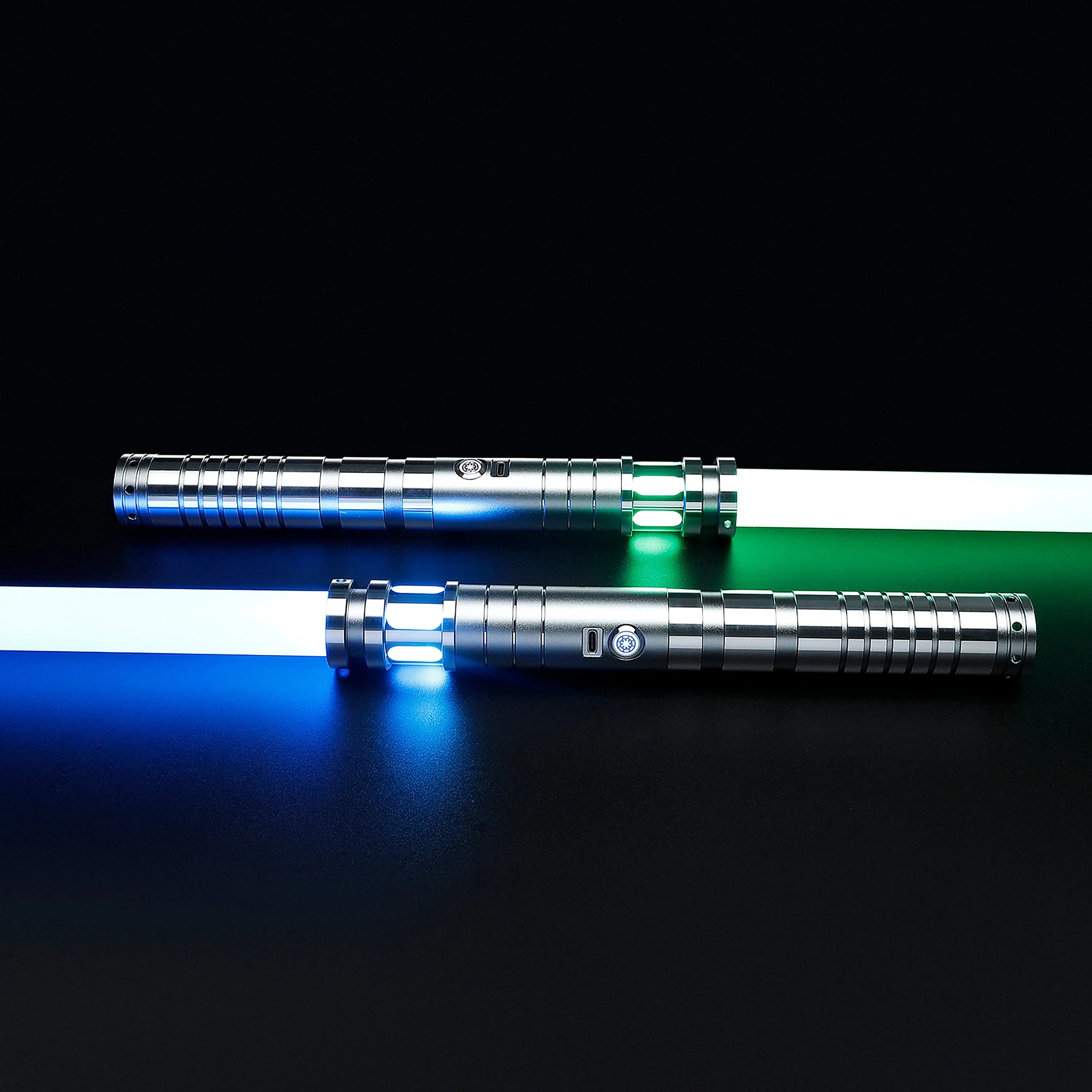 Two Sol aluminum lightsabers with glowing blue and green polycarbonate blades on a black background.