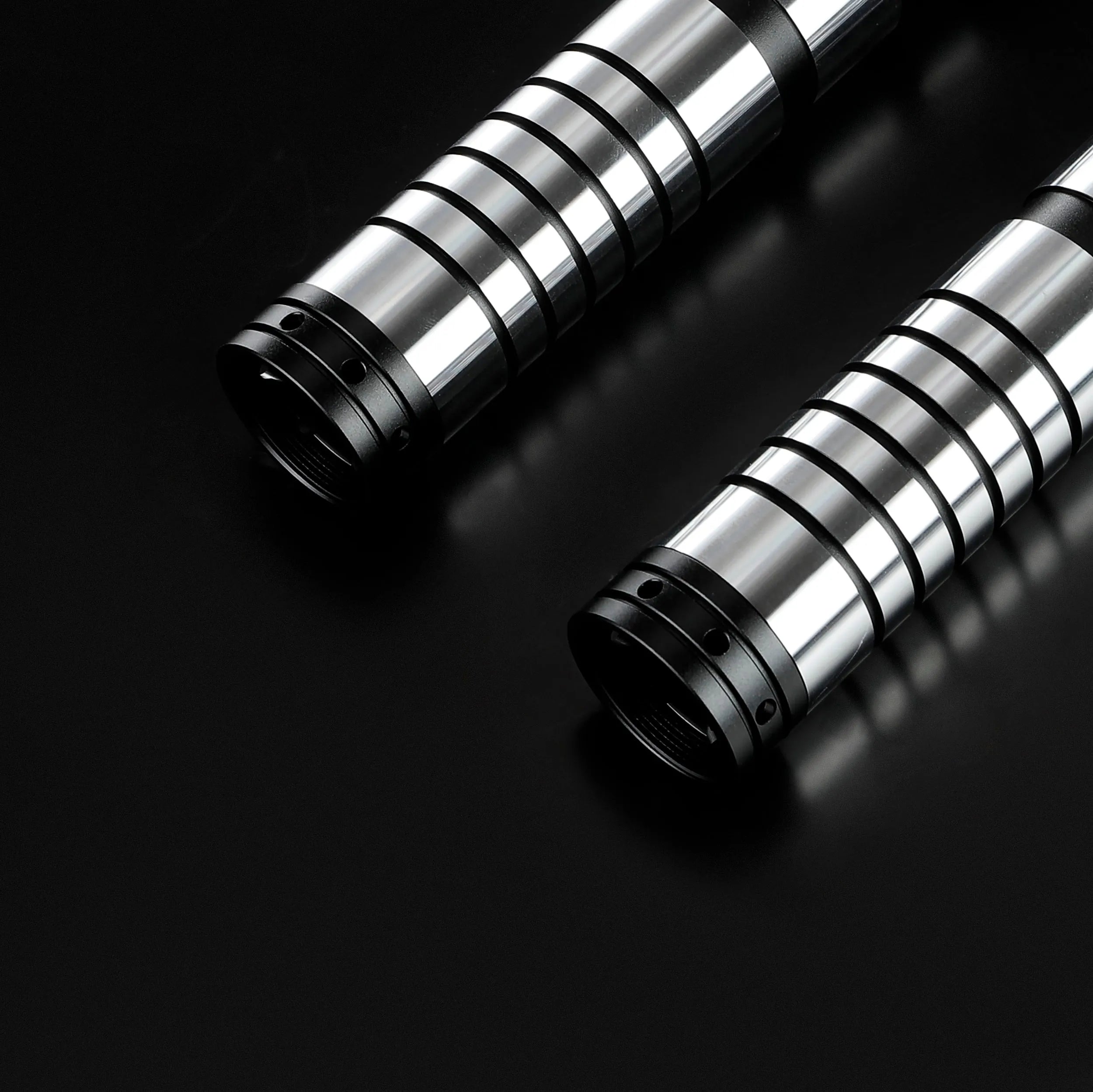 Two Sol lightsaber hilts crafted from sleek silver and black T6 aircraft aluminum on a black background.